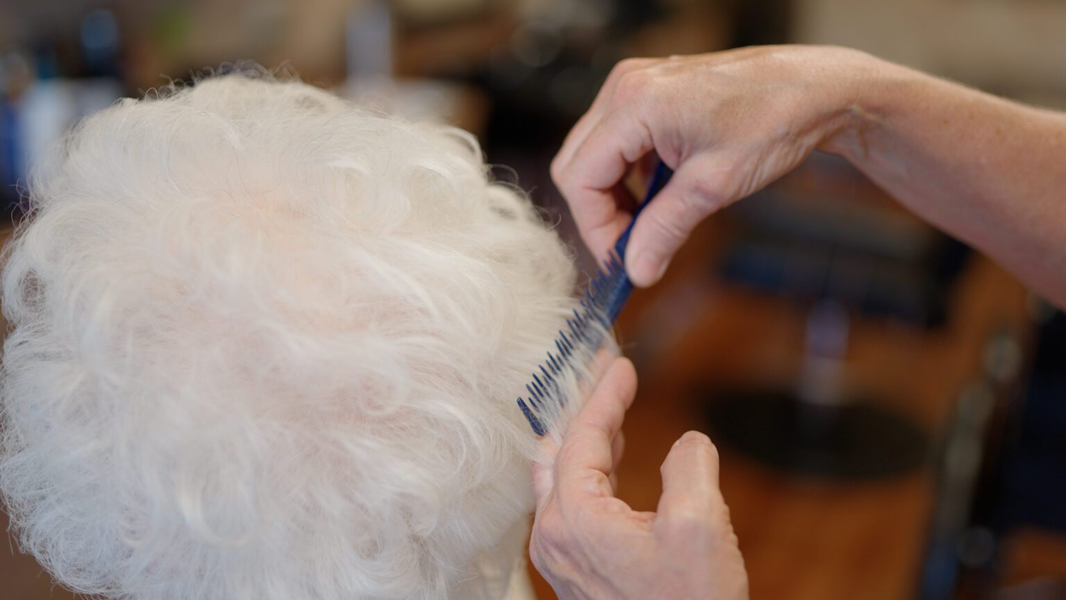 A woman gets her hair done at a skilled nursing facility nursing home